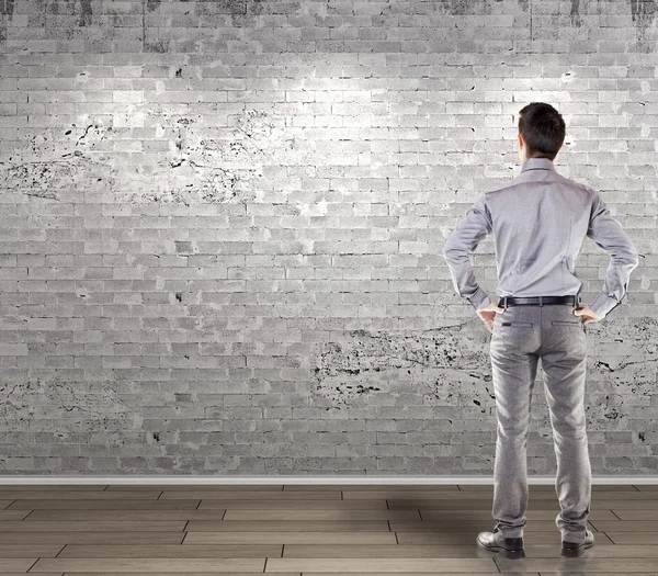 Joven hombre de negocios atractivo frente a una antigua pared en blanco vintage — Foto de Stock