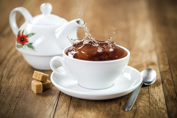 Свежий здоровый чай всплеск в чашку чая — стоковое фото