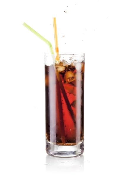 Zumo de cola fresca y cubitos de hielo salpican en un vaso sobre fondo negro — Foto de Stock