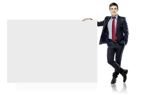 Atraente jovem homem de negócios e placa em branco no fundo branco — Fotografia de Stock