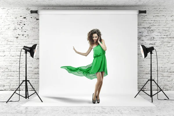Молодая красивая женщина в зеленом платье позирует в студии — стоковое фото