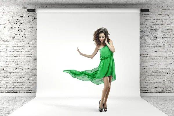 Young beautiful woman in green dress posing in studio Royalty Free Stock Images