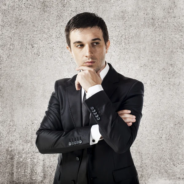 Young businessman on grunge background — Stock Photo, Image