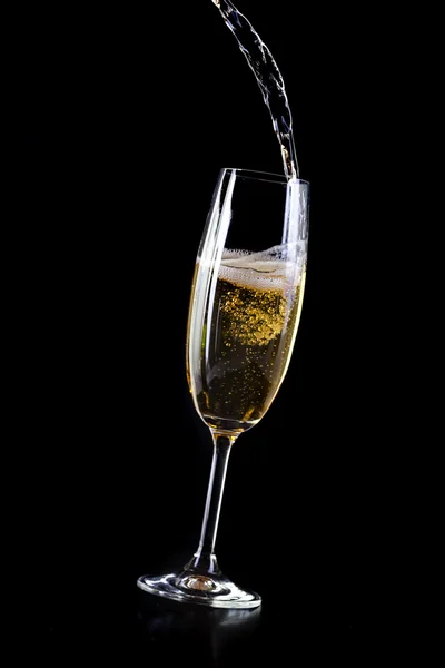 Champagne pouring in crystal glass, on black background — Stock Photo, Image