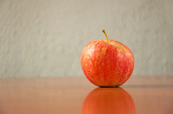 Červené jablko na stole — Stock fotografie