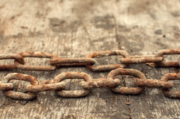 Rusty chain and weathered wood background — Stock Photo, Image