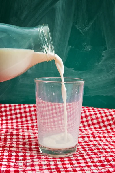 Выливание молока в стекло — стоковое фото