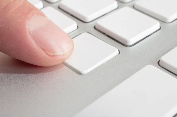 Finger pressing a computer key — Stock Photo, Image