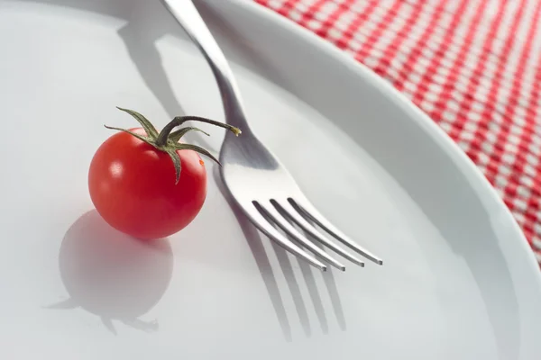 Tomate cereja e garfo na placa — Fotografia de Stock