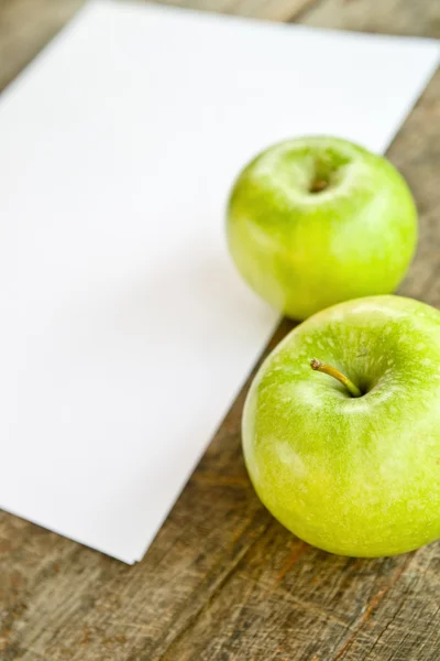 Green apples and white paper — Stock Photo, Image