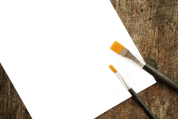 Paint brushes and white paper — Stock Photo, Image