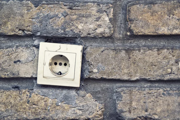 Conector de enchufe eléctrico, toma de corriente alterna, en pared de ladrillo . — Foto de Stock