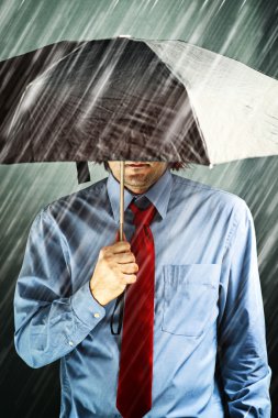fırtınada şemsiye ile işadamı