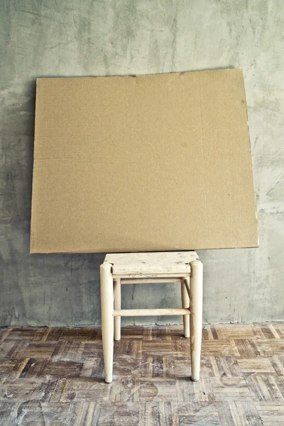 Eski vintage sandalye ve boş karton — Stok fotoğraf