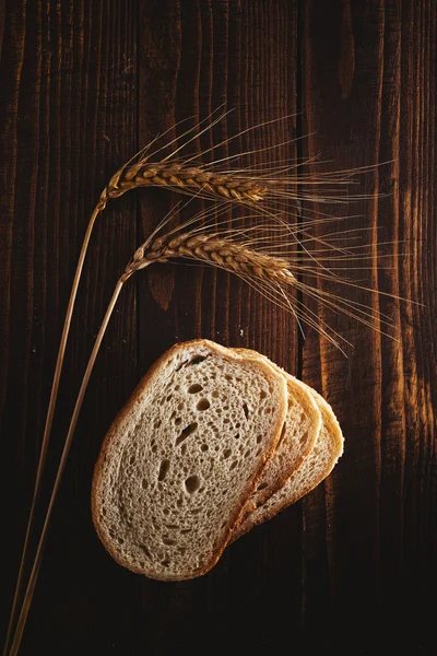 Rebanadas de pan, espigas de trigo y granos — Foto de Stock