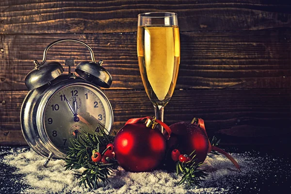 Weihnachtskugeln und Vintage-Uhr mit Glas Champagner — Stockfoto