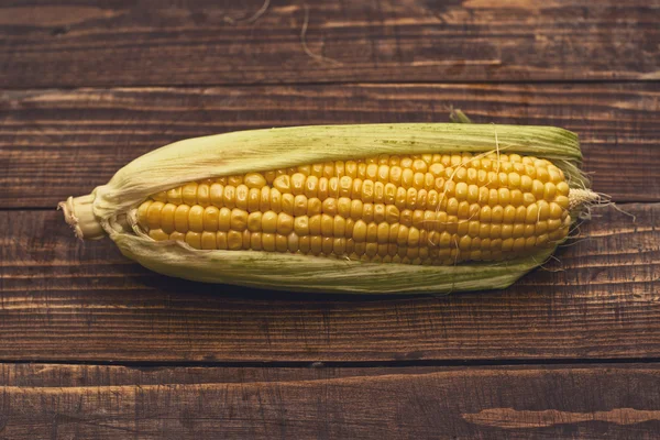 Ухо кукурузы на деревянном фоне — стоковое фото
