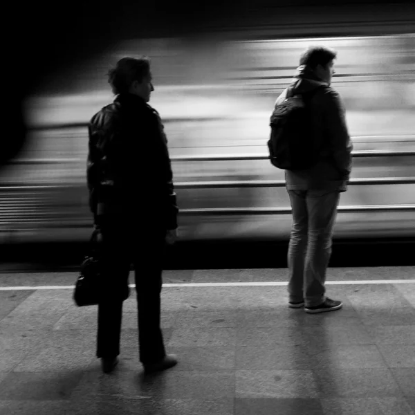 As pessoas na plataforma da estação de metrô de Belgrado Vukov spomenik olhando para o trem que passa por eles — Fotografia de Stock