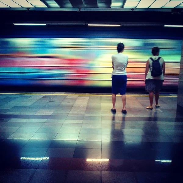 Menschen auf dem Bahnsteig der belgrader U-Bahn-Station vukov spomenik schauen auf schnell fahrenden Zug, der an ihnen vorbeifährt. — Stockfoto