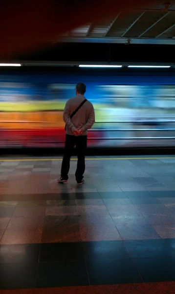 Belgrad metro istasyonu vukov spomenik ayakta, hızlı tren geçerken bakarak bir adam. işçi sınıfı Belgrad'da çalışmak için yolda ulaşım biçimi olarak şehir treni kullanmak. — Stok fotoğraf