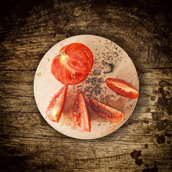 Sliced tomato on wooden plate — Stock Photo, Image
