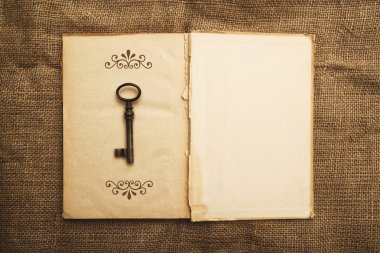 eski açık kitap ve paslı anahtar