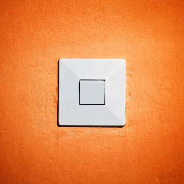 Винтажный выключатель на оранжевой стене — стоковое фото