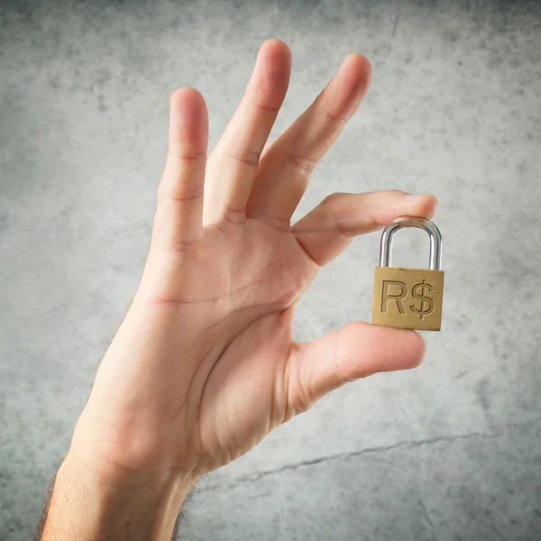 Hand hält Vorhängeschloss mit brasilianischem Echtwährungssymbol — Stockfoto