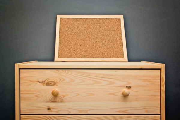 Cork memory board on wooden cabinet — Stock Photo, Image