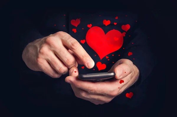 Mann tippt Liebes-SMS auf Smartphone für Valentinstag — Stockfoto