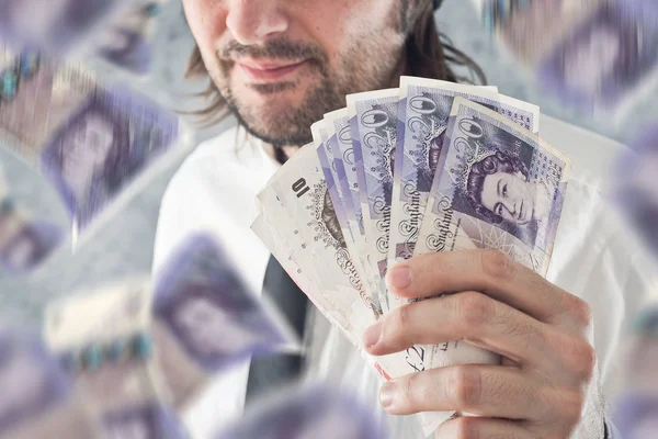 Επιχειρηματίας που κατέχουν βρετανικές λίρες χρήματα, bnknotes πτώση από — Φωτογραφία Αρχείου