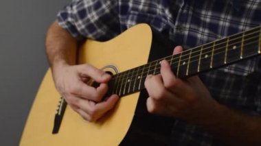 Adam akustik gitar çalıyor.,