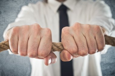 bir ip sıkı tutan işadamı