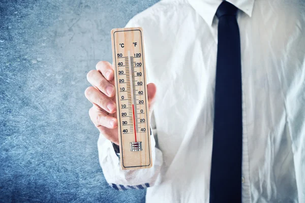 Homem de negócios segurando termômetro com temperatura no valor Zero — Fotografia de Stock