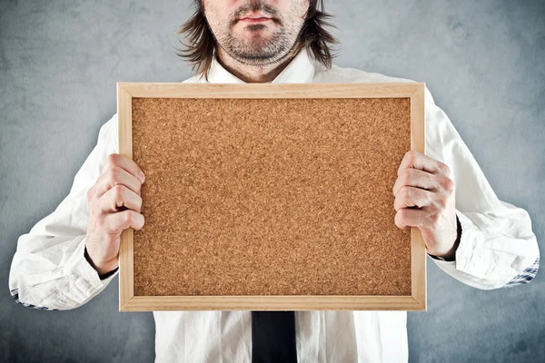 Empresário segurando quadro de avisos em branco — Fotografia de Stock