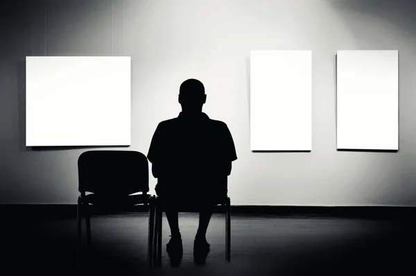 Sanat galerisinde oturan adam — Stok fotoğraf