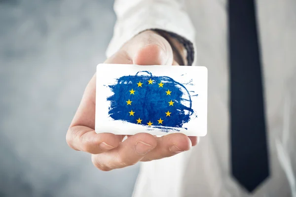 Empresario europeo titular de una tarjeta de visita con bandera de la UE — Foto de Stock