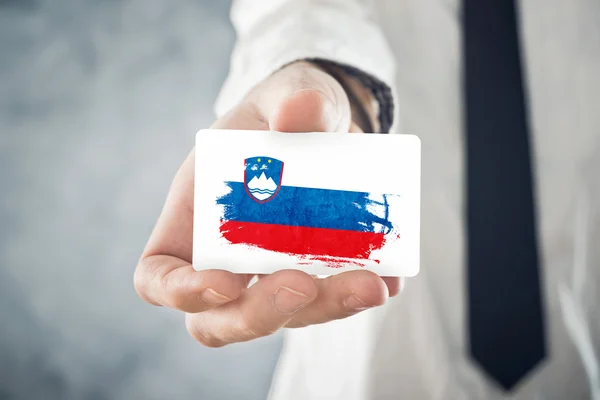 Словенский бизнесмен с визитной карточкой под Словенским флагом — стоковое фото