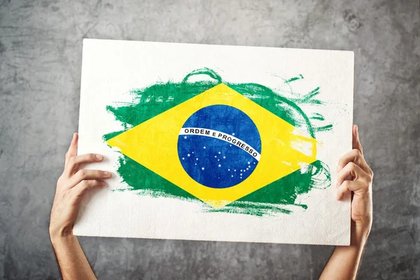 Bandera de Brasil. Hombre sosteniendo bandera con bandera brasileña . — Foto de Stock