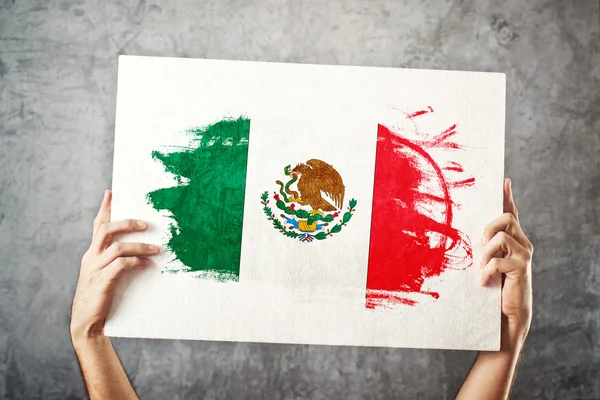 Флаг Мексики. Человек держит знамя с мексиканским флагом . — стоковое фото
