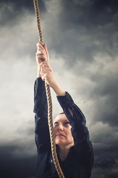 Kvinna klättra upp med rep — Stockfoto