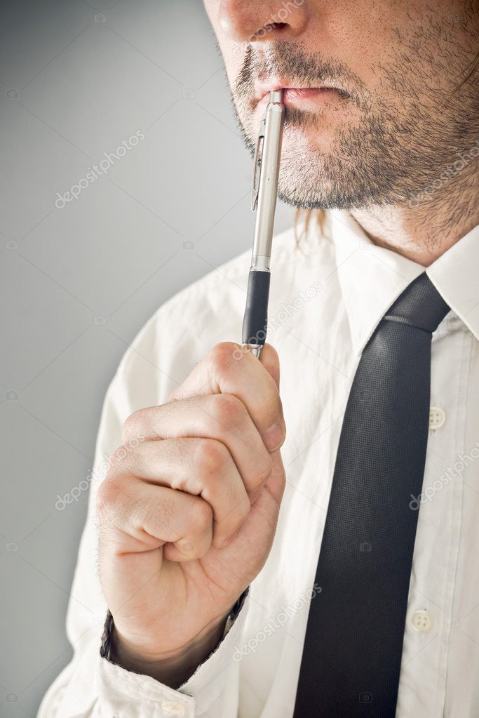 Businessman thinking with pencil in his mouth