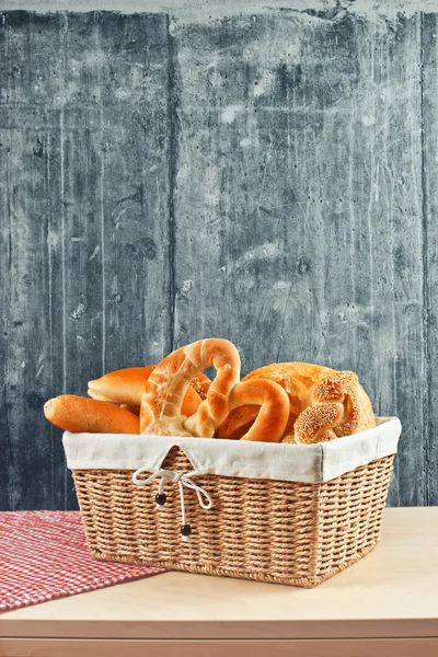Leckeres Brot und Brötchen im Weidenkorb — Stockfoto