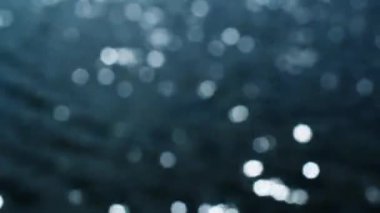 su yüzeyi parlak güneşin altında dalgaları ile. odak dışında yansıyan güneş kamaşma bokeh.