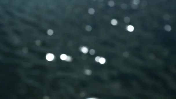 Surface de l'eau avec des vagues scintillantes au soleil. Hors foyer bokeh de soleil reflets réfléchis .