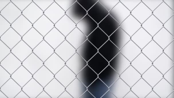 Uomo con problemi solo sulla strada dietro la recinzione a catena. Concetto di tossicodipendenza . — Video Stock