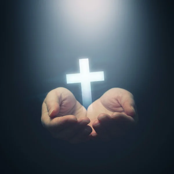 Mãos abertas segurando cruz Cristianismo — Fotografia de Stock