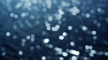 su yüzeyi parlak güneşin altında dalgaları ile. odak dışında yansıyan güneş kamaşma bokeh.