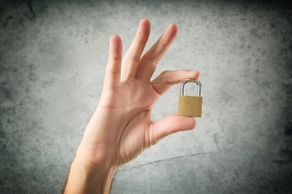 Hand holding locked padlock — Stock Photo, Image