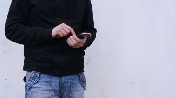 A férfi okostelefont használ a szabadban. Kezek görgetése és szalagra a képernyőn az okostelefon eszköz. — Stock videók